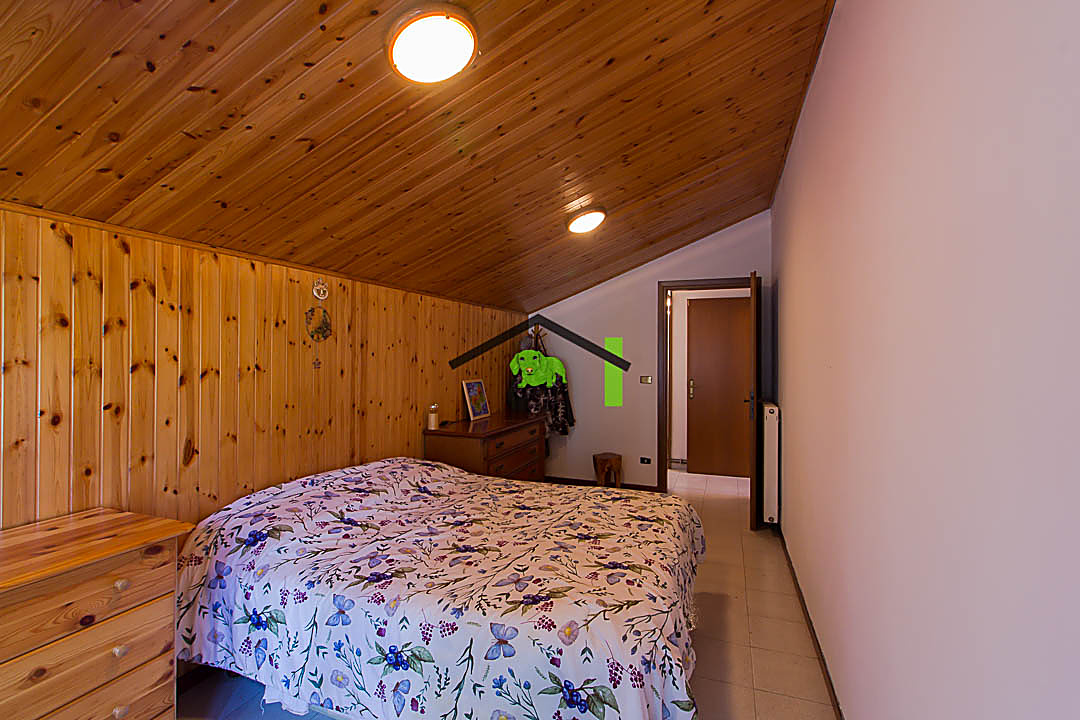 Camera da letto mansardata con letto matrimoniale